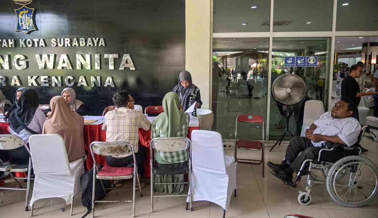 Acara ini diharapkan dapat memperluas kesempatan kerja sekaligus memperkuat komitmen Pemkot Surabaya terhadap pemberdayaan penyandang disabilitas. Tampak dalam foto, para penyandang disabilitas menunggu untuk menyerahkan formulir lamaran mereka dalam bursa kerja yang diselenggarakan pemerintah daerah di Surabaya, Jawa Timur, pada Selasa 25 November 2025. (JUNI KRISWANTO/AFP)