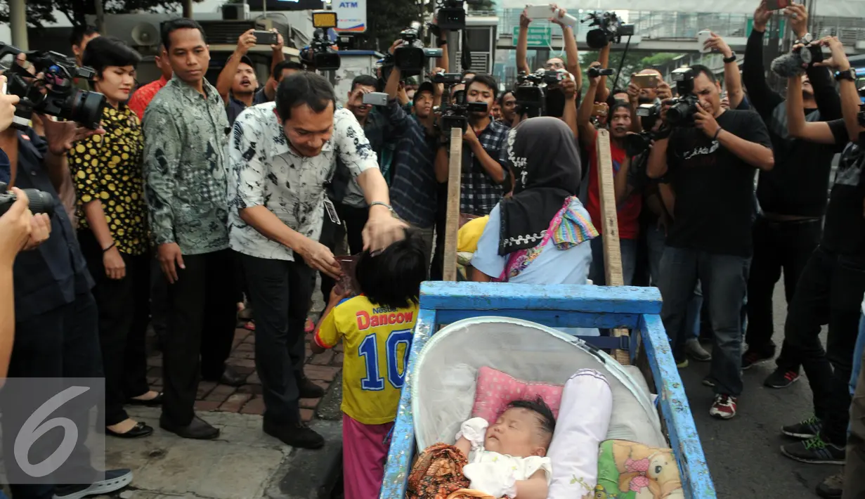 Wakil Ketua KPK Saut Situmorang memberikan makanan untuk berbuka puasa (takjil) kepada pemulung di depan Gedung KPK, Jakarta, Rabu (29/6). KPK memberikan takjil gratis kepada pengendara yang melintasi jalan HR Rasuna Said. (Liputan6.com/Helmi Afandi)