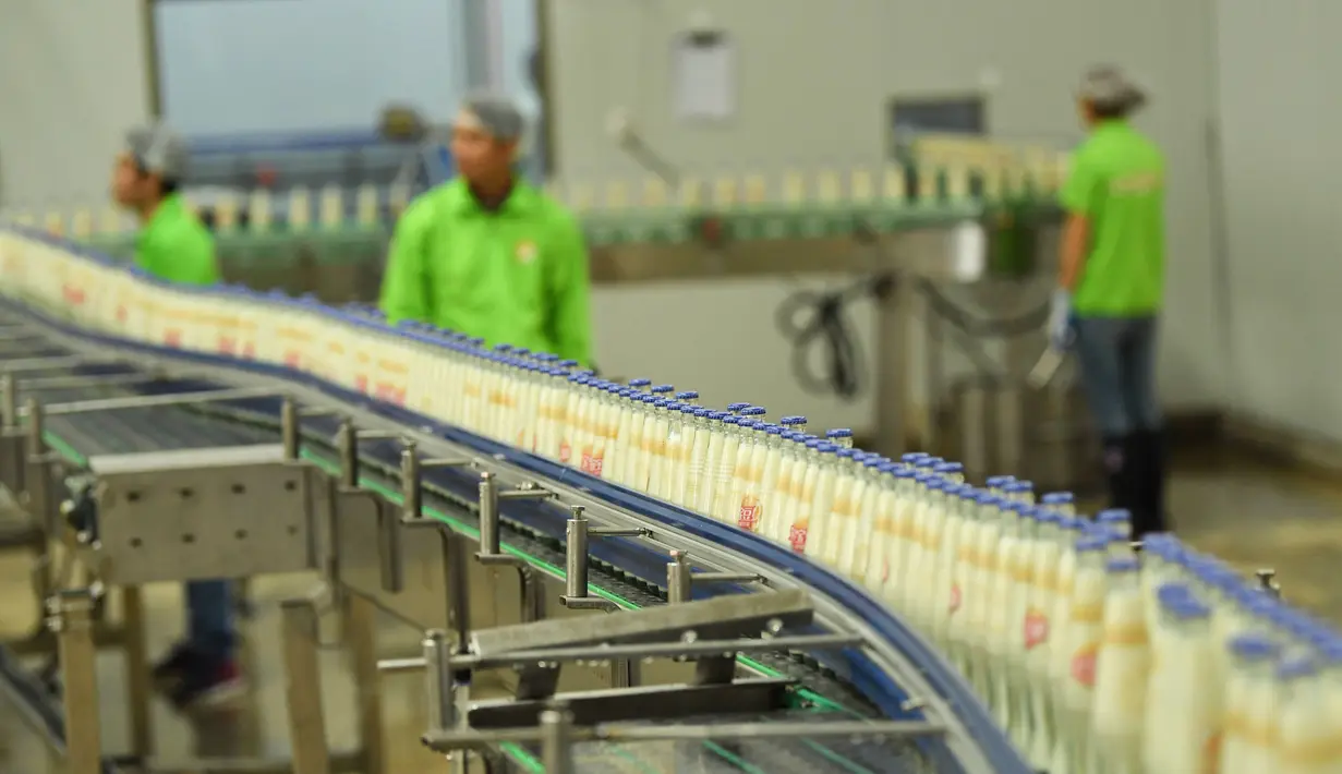 Pekerja memantau jalur produksi susu kedelai di sebuah pabrik di Nanning, Guangxi, China, Selasa (12/3). Produksi industri China turun ke level terendah dalam 17 tahun terakhir. (STR/AFP)