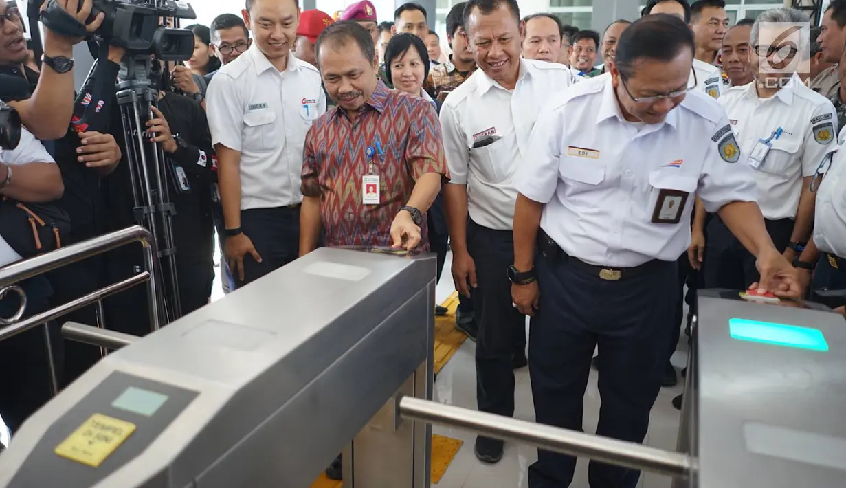 Direktur PT KAI Edi Sukmoro bersama Sekda Kota Tangerang, Tatang Sutisna melakukan tapping e-ticketing usai peresmian jembatan penghubung atau skybridge antara peron 1-2 (KA Bandara) dengan peron 3-4 (KRL) di Stasiun Batu Ceper, Tangerang, Kamis (18/7/2019). (Liputan6.com/Immanuel Antonius)