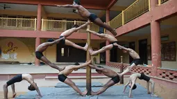 Pesenam berlatih Mallakhamba dengan sebuah tiang di Ahmedabad, Senin (28/1). Olahraga kuno ini membuat seseorang menjadi lincah dan gesit, memperbaiki koordinasi tubuh dan pikiran selain untuk tujuan fitness. (SAM PANTHAKY / AFP)