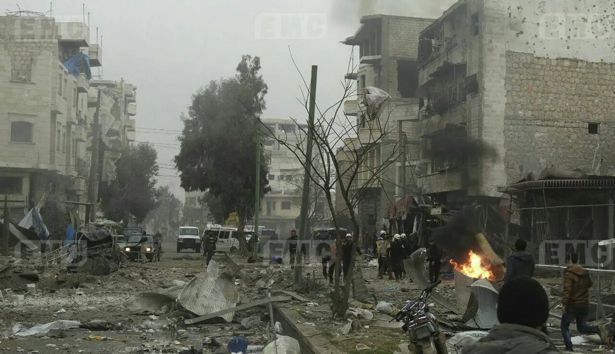 Relawan White Helmets memadamkan kobaran api bekas serangan militer di Provinsi Idlib, Suriah, Minggu, (7/1). Laporan mengatakan bahwa ledakan merupakan bom mobil, sementara lainnya menyebut serangan drone. (Syrian Civil Defense White Helmets via AP)