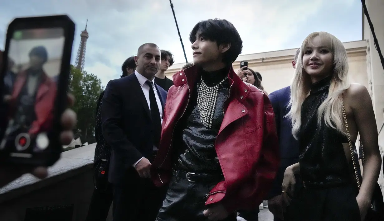 V BTS (kiri) dan Lisa Blackpink (kanan) berpose untuk fotografer sebelum koleksi Celine men's Spring Summer 2023 dipresentasikan di Paris, Prancis, 26 Juni 2022. Bagi V BTS, ini menjadi acara pertama dirinya menghadiri fashion show di luar negeri sendirian tanpa member BTS lainnya. (AP Photo/Francois Mori)