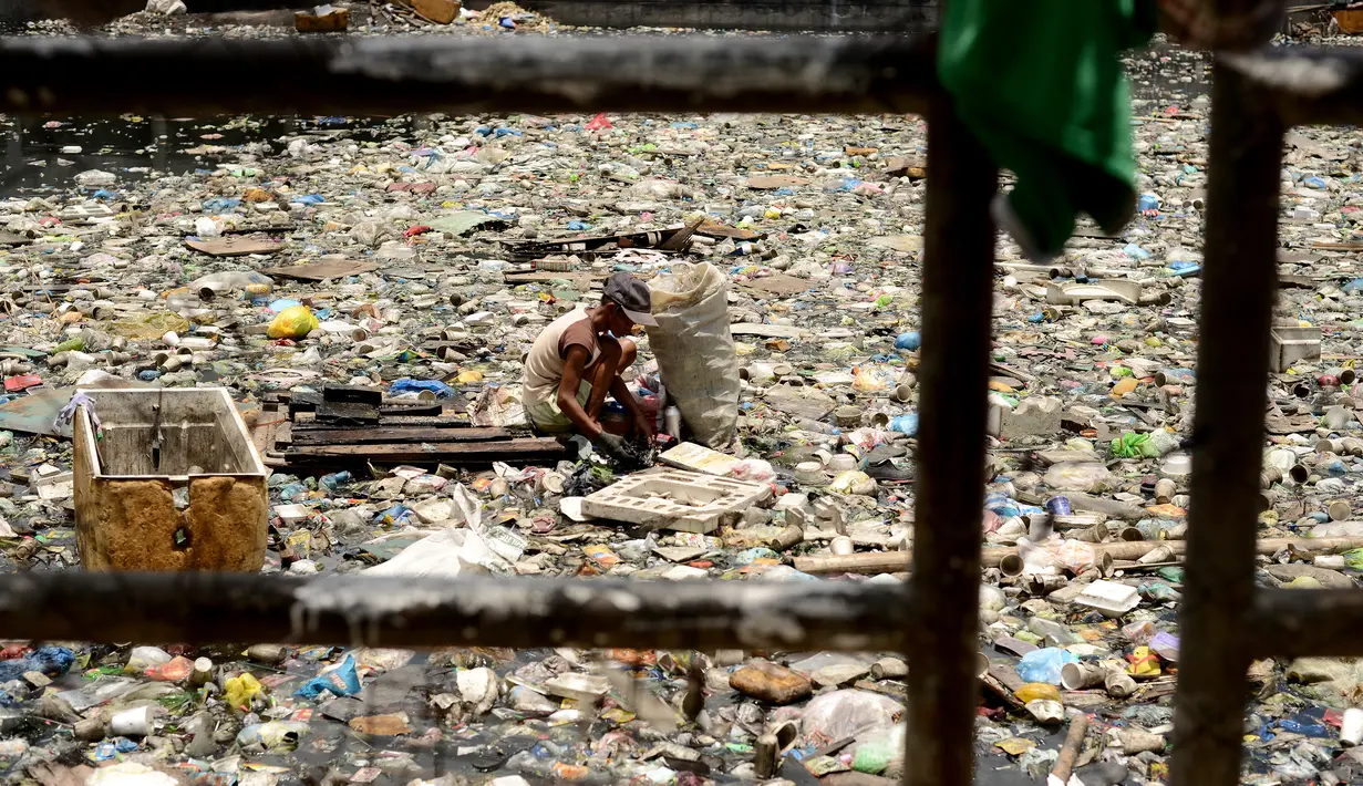Teresita Gapayao (51) mengais sampah yang masih dapat difungsikan di aliran Sungai Estero de Vitas di Tondo, Manila, Filipina, Kamis (21/4). Teresita sudah 12 tahun menafkahi keluarganya dari sampah-sampah yang bisa di daur ulang. (Noel CELIS/AFP)