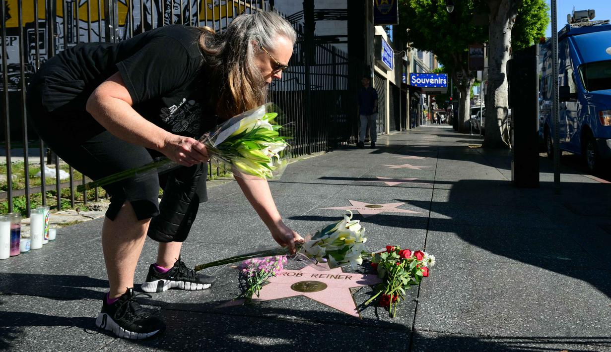 Sebagai informasi, Rob Reiner dikenal sebagai figur berpengaruh yang meninggalkan jejak kuat lewat karya lintas genre sejak era televisi hingga film modern. Tampak dalam foto, seorang wanita meletakkan bunga di bintang Hollywood Walk of Fame milik aktor sekaligus sutradara Amerika Serikat, Rob Reiner, di Los Angeles, California, pada Senin 15 Desember 2025. (Frederic J. Brown/AFP)