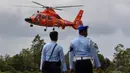 Dua personil TNI AU bersiaga jelang mendarat helikopter yang membawa jenazah korban pesawat AirAsia QZ8501 di Lanud Iskandar, Pangkalan Bun, Kalteng, Rabu (31/12/2014). (Liputan6.com/Miftahul Hayat)