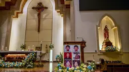 Potret para korban bom bunuh diri terlihat saat orang-orang menghadiri upacara peringatan di Gereja Katolik Santa Maria, Surabaya, Jawa Timur, pada 13 Mei 2025. (Juni KRISWANTO/AFP)