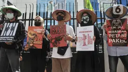 Aktivis Gerakan Rakyat untuk Kedaulatan Agraria membawa poster saat aksi mogok makan di depan Kantor Kementerian ATR/BPN, Jakarta, Senin (20/2/2023). Untuk menunjukkan aksi mogok makannya, mereka menggunakan masker dengan tanda silang hitam. (merdeka.com/Iqbal S Nugroho)