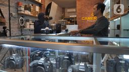 Calon pembeli mencoba kamera bekas  yang dijual belikan di CSZ Camera di kawasan Pondok jagung, Tangerang Selatan, Banten, Senin (20/12/2021). Peningkatan penjualan didorong karena kebutuhan memotret untuk komunitas dan media visual penjualan online. (merdeka.com/Arie Basuki)
