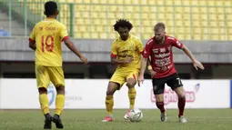 Striker Bali United, Melvin Platje, berebut bola dengan gelandang Bhayangkara FC, Hedipo Gustavo, pada laga Shopee Liga 1 di Stadion Patriot Chandrabhaga, Bekasi, Jumat (13/9). Bhayangkara bermain imbang 0-0 atas Bali United. (Bola.com/Yoppy Renato)