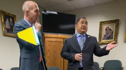 Ketua House Transportation Committee, Del. Ron Villanueva (kanan) sedang berbicara dengan kliennya, David Catania saat uji coba Robot Pengirim di Virginia, AS (25/1). Dengan hadirnya robot ini diharapkan dapat membantu manusia.(AP Photo/Steve Helber)