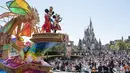 <p>Karakter Disney Mickey dan Minnie Mouse (kiri atas) melambai saat parade siang hari baru di Urayasu, di pinggiran kota Tokyo pada 10 April 2023. (AFP/Richard A. Brooks)</p>