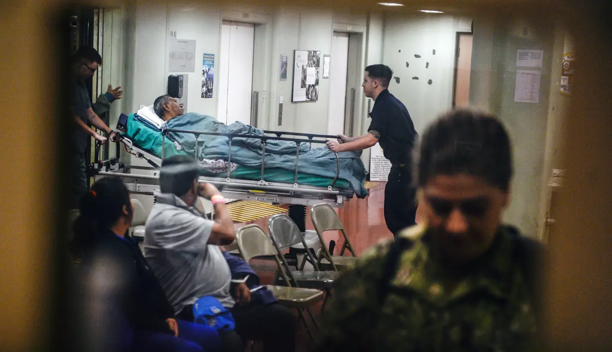 Seorang pasien dibawa oleh staf di atas kapal rumah sakit Angkatan Laut AS USNS Comfort yang berlabuh di wilayah Piura, Peru, 5 November 2018. Lebih dari 5.000 orang, termasuk imigran Venezuela dirawat oleh personel AS. (ERNESTO BENAVIDES / AFP)