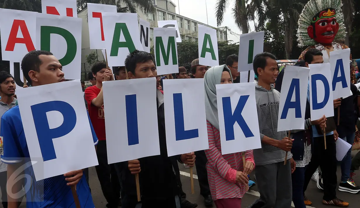 Sejumlah orang yang tergabung dalam Koalisi Pilkada Damai Tanpa Kecurangan (KPD-TK) memegang tulisan Pilkada Damai Anti Curang di kawasan hari bebas kendaraan di Bundaran HI, Jakarta, Minggu (2/4). (Liputan6.com/Johan Tallo)