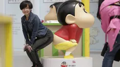 Seorang wanita berpose mengikuti gaya Crayon Shinchan saat berfoto di pameran Joy City, Beijing (5/5/2015). Lima puluh model karakter kartun Jepang dalam berbagai pose dan ekspresi dihadirkan dipameran tersebut. (REUTERS/Jason Lee)