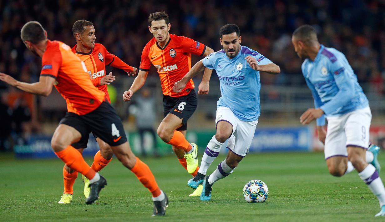 Gelandang Manchester City, Ilkay Gundogan berlari sambil membawa bola menghindari hadangan pemain Shakhtar Donetsk pada laga pertama Grup C Liga Champions di Metalist Stadium, Rabu (18/9/2019). Manchester City sukses menghantam Shakhtar Donetsk dengan skor 3-0. (AP Photo/Efrem Lukatsky)