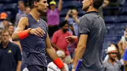 Petenis Spanyol, Rafael Nadal dan Dominic Thiem dari Austria usai pertandingan perempat final turnamen AS Terbuka 2018 di New York, AS, (5/9). Nadal menang lewat pertarungan maraton lima set 0-6, 6-4, 7-5, 6-7 (4-7), 7-6 (7-5). (AP Photo/Adam Hunger)
