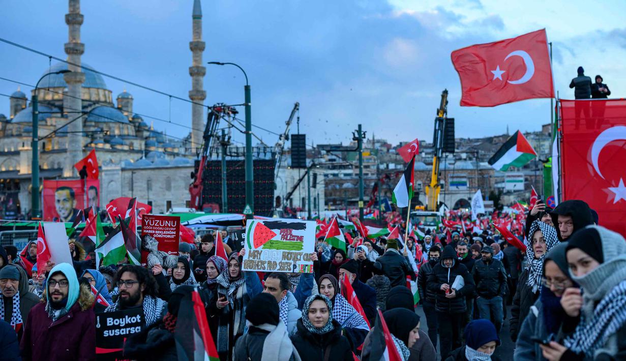 Menurut berbagai sumber medis pada Rabu 31 Desember 2025, sejak serangan Israel dimulai pada Oktober 2023 lalu, jumlah korban tewas telah mencapai lebih dari 71.269 orang. Tampak dalam foto, orang-orang mengibarkan bendera Turki dan bendera Palestina saat mereka berdemonstrasi sebagai bentuk solidaritas dengan rakyat Palestina di tengah perang yang sedang berlangsung antara Israel dan kelompok Hamas di wilayah Gaza, di Jembatan Galata, Istanbul, Turki pada 1 Januari 2026. (Yasin AKGUL/AFP)