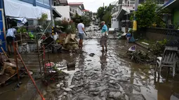 Warga membersihkan rumah mereka setelah banjir akibat Topan Goni yang melanda Kota Batangas di selatan Manila, Filipina, Senin (2/11/2020). Goni, sebuah topan kategori 5 yang disebut-sebut sebagai topan terkuat sepanjang 2020, menghantam Filipina pada Minggu, 1 November 2020. (TED ALJIBE / AFP)
