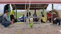 Keluarga Ajak Jaya melaksanakan ritual di Keramat Batu yang berada di tengah areal yang dibuka untuk ditanami sawit milik PT Bina Sarana Sawit Utama di Desa Marakit, Kecamatan Kapuas Tengah, Kabupaten Kapuas, Kalimantan Tengah, Rabu (27/3/2024).