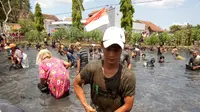 Salah satu warga berhasil menangkap ikan dalam kegiatan ngagogo untuk merayakan kesuksesan jagoan mereka dalam pilkades serentak Selasa lalu (Liputan6.com/Jayadi Supriyadin)