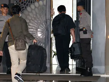 Dua penyidik KPK masuk ke dalam rumah tersangka Ketua DPR RI Setya Novanto dengan membawa tas warna hitam di Jalan Wijaya 13 No 19, Jakarta Selatan, Rabu (15/11). (Liputan6.com/Johan Tallo)