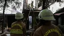 Petugas pemadam kebakaran melakukan proses pendinginan pada permukiman penduduk yang terbakar di Jalan Masjid Alhuda atau depan Stasiun Kebayoran Lama RT 05/01, Jakarta Selatan, Selasa (24/5/2022). Petugas pun mengerahkan 27 unit mobil pemadam kebakaran dari Sudin Damkar Jakarta Selatan ke lokasi kejadian. (Liputan6.com/Johan Tallo)