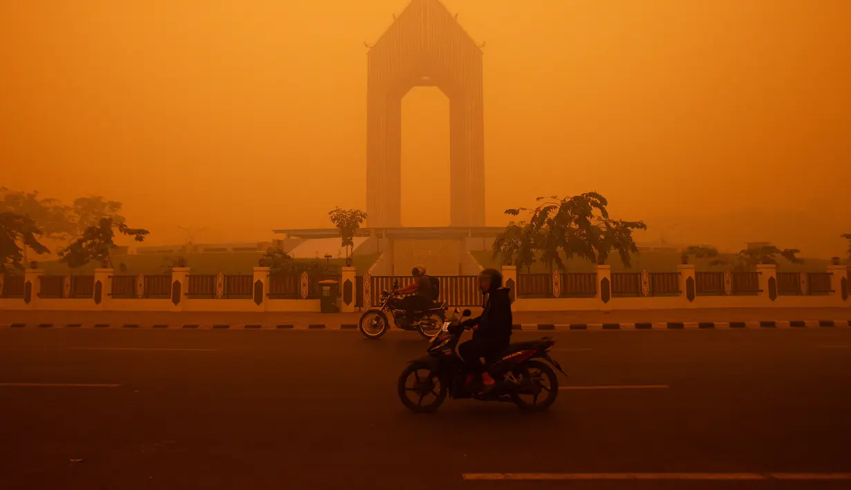 Pengendara sepeda motor melintas di tengah kabut asap tebal akibat kebakaran hutan dan lahan di Palangkaraya, Kalimantan Tengah, Rabu (14/10/2026). Kebakaran yang menghanguskan area luas di Kalimantan dan Sumatra menyebabkan kabut asap berbahaya menyelimuti sejumlah wilayah di Indonesia, Malaysia, dan Singapura selama beberapa pekan. Kondisi tersebut berdampak pada kualitas udara dan aktivitas masyarakat di kawasan terdampak. (REINA/AFP)