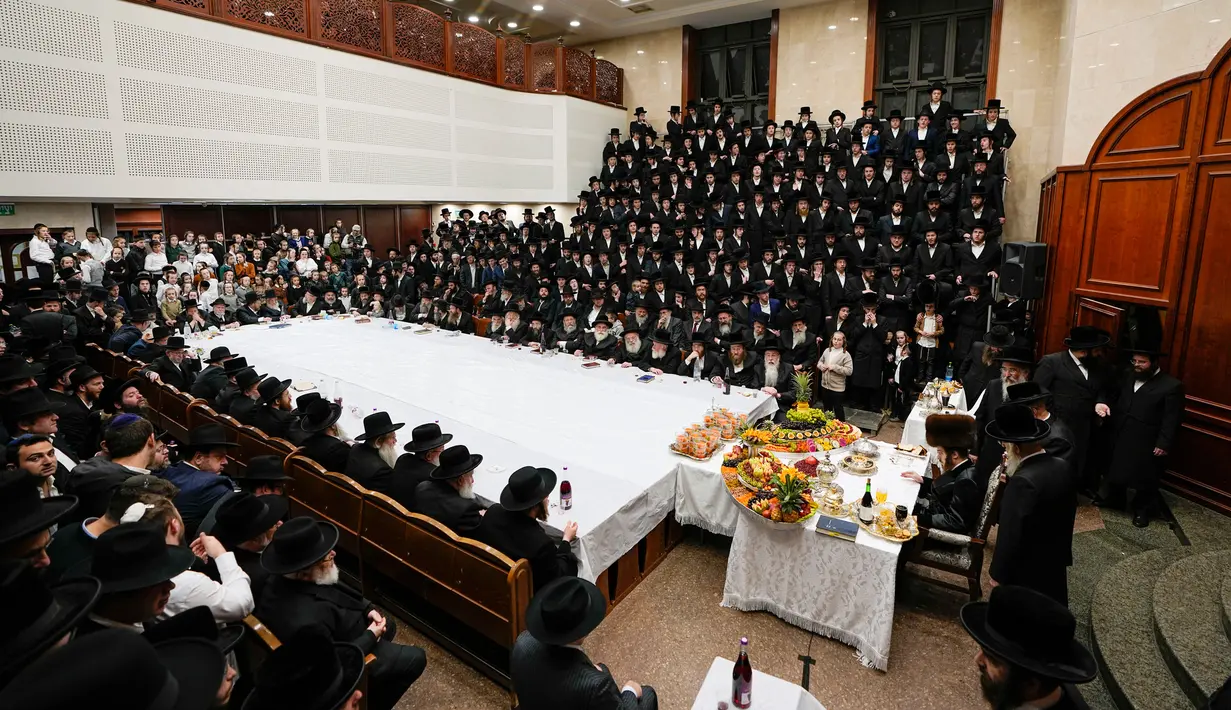 Orang-orang Yahudi Ultra-Ortodoks dari dinasti Hasid Sadigura merayakan Hari Raya Tu Bishvat atau Tahun Baru Pohon di Yerusalem, 5 Februari 2023. Saat perayaan Tahun Baru Pohon, orang-orang Yahudi Ultra-Ortodoks berkumpul dengan para rabi mereka di sekitar meja panjang berisi piring-piring berisi beberapa jenis buah-buahan. (AP Photo/Ariel Schalit)