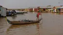 Seorang anak laki-laki mendayung perahu di sungai Siem Reap di Siem Reap, Kamboja (5/12/2019). Sungai Siem Reap adalah sungai yang mengalir melalui Provinsi Siem Reap, di barat laut Kamboja. (AFP/Manan Vatsyayana)