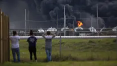 Warga mengamati kebakaran pabrik TPC Group yang meledak di Port Neches, Texas (27/11/2019). Dua ledakan besar 13 jam terpisah membakar pabrik kimia dan menyebabkan tiga pekerja terluka. (Marie D. De Jesús/Houston Chronicle via AP)