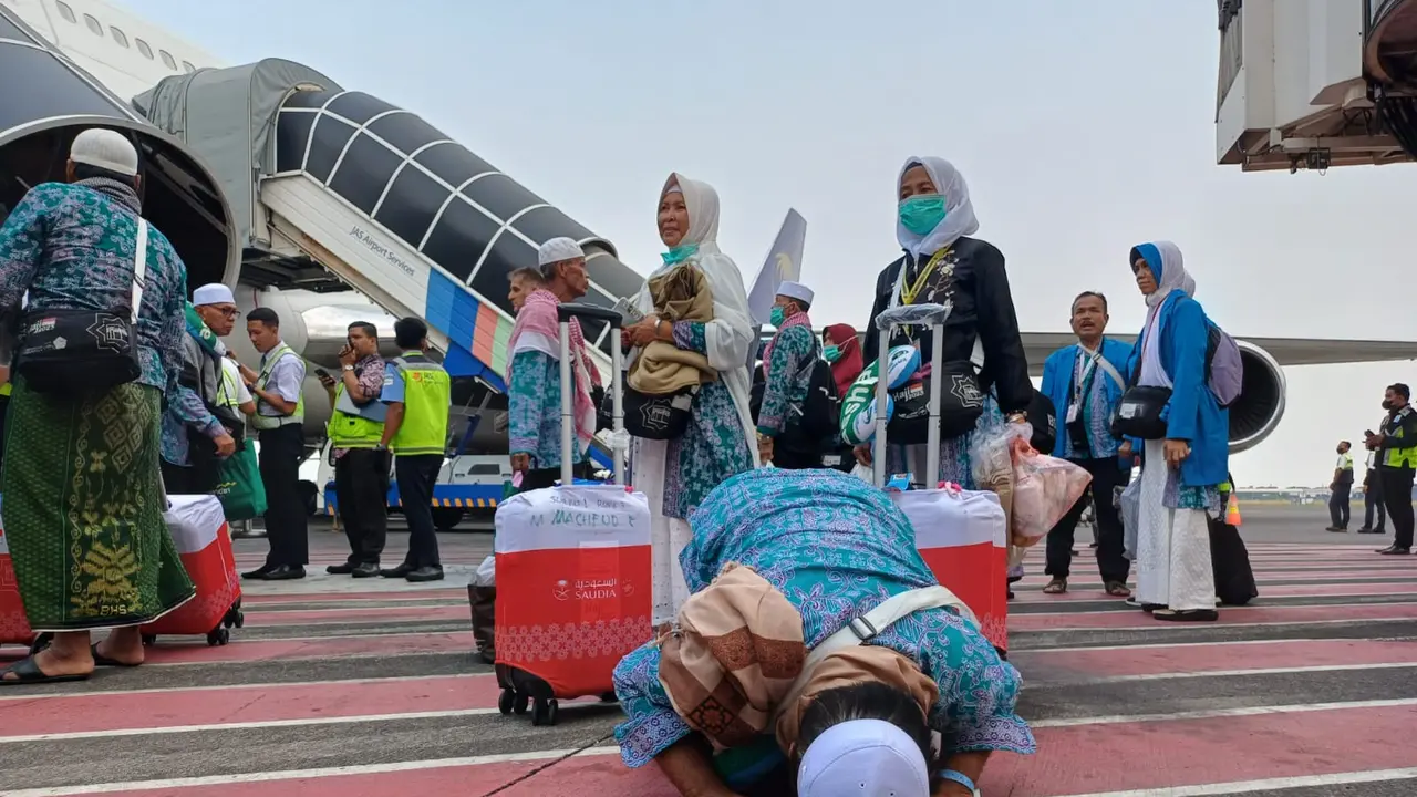 Jemaah haji melakukan sujud syukur usai tiba di bandara Juanda. (Dian Kurniawan/Liputan6.com)