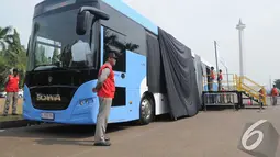 Bus baru Transjakarta yang dominan dengan warna biru ditutupi logonya dengan kain hitam sebelum acara peresmian dimulai, Senin (10/11/2014) (Liputan6.com/Herman Zakaria)