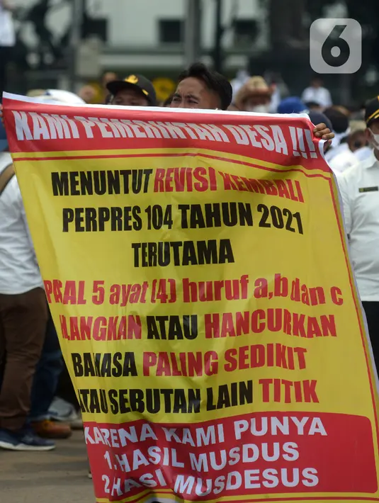 Massa Asosiasi Pemerintah Desa Seluruh Indonesia (Apdesi) membentangkan spanduk tuntutan saat melakukan unjuk rasa di kawasan Silang Monas, Jakarta, Kamis (16/12/2021). Apdesi menuntut Presiden Joko Widodo merevisi Perpres Nomor 104 Tahun 2021 tentang Rincian APBN 2022. (merdeka.com/Imam Buhori)