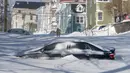Sebuah mobil setengah terkubur salju di Kota St John's, Newfoundland, Kanada, Sabtu (18/1/2020). St John's menghadapi keadaan darurat ketika salju tebal memaksa pusat-pusat bisnis tutup dan kendaraan dilarang melintas di jalan raya. (Andrew Vaughan/The Canadian Press via AP)