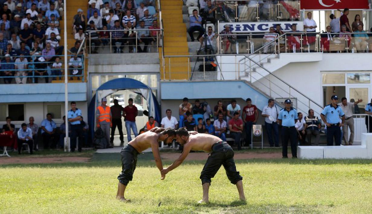 Penonton memadati tribun stadion saat pertandingan gulat digelar. (AFP Photo/Adem Altan)