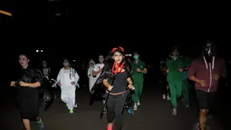 Salah satu wanita berlari menggunakan kostum menyeramkan saat merayakan perayaan Halloween di kawasan Stadion Gelora Bung Karno, Jakarta, Kamis (30/10/2014). Halloween merupakan tradisi perayaan malam 31 Oktober. (Liputan6.com/Helmi Fithriansyah)