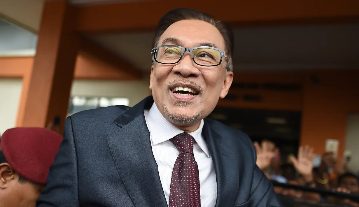 Mantan pemimpin oposisi Malaysia, Anwar Ibrahim berjalan bebas keluar dari RS Rehabilitasi Cheras, Kuala Lumpur, Rabu (16/5). Anwar tersenyum dan melambaikan tangansebelum masuk ke dalam mobil menuju istana untuk bertemu raja. (AFP/MOHD RASFAN)