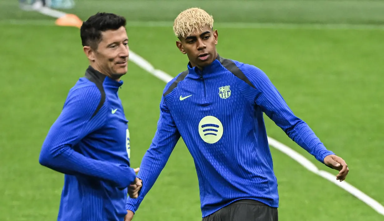 Pemain Barcelona, Lamine Yamal (kanan) dan Robert Lewandowski tampak dalam latihan menjelang laga leg 2 semifinal Liga Champions 2024/2025 melawan Inter Milan di Giuseppe Meazza, Milan, Italia. (AFP/Piero Cruciatti)