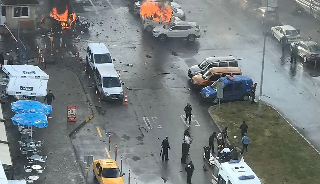 Sejumlah mobil terbakar setelah ledakan terjadi di luar sebuah pengadilan di kota Izmir, wilayah barat Turki, Kamis (5/1). Sedikitnya 10 orang terluka akibat kejadian ini. (DHA/Dogan News Agency/AFP)