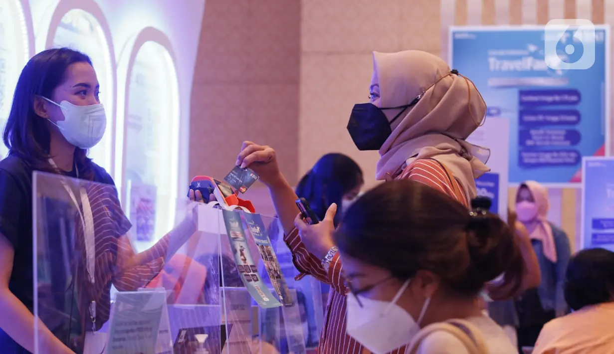 Nasabah betransaksi pembeliaan tiket dengan kartu Co-brand BNI Garuda dalam pameran perjalanan wisata GATF Hybrid 2021, Sabtu (11/12/2021). Garuda Indonesia Travel Fair PT Bank Negara Indonesia memberikan diskon 
hingga Rp1,75 juta, cicilan 0% hingga 12 bulan. (Liputan6.com/Fery Pradolo)