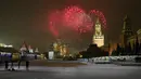 Wartawan menyaksikan kembang api meledak di atas Katedral St. Basil dan Kremlin dengan Menara Spasskaya di Lapangan Merah yang kosong karena pembatasan pandemi COVID-19 saat perayaan Tahun Baru di Moskow, Rusia, Sabtu (1/1/2022). (AP Photo/Alexander Zemlianichenko Jr)