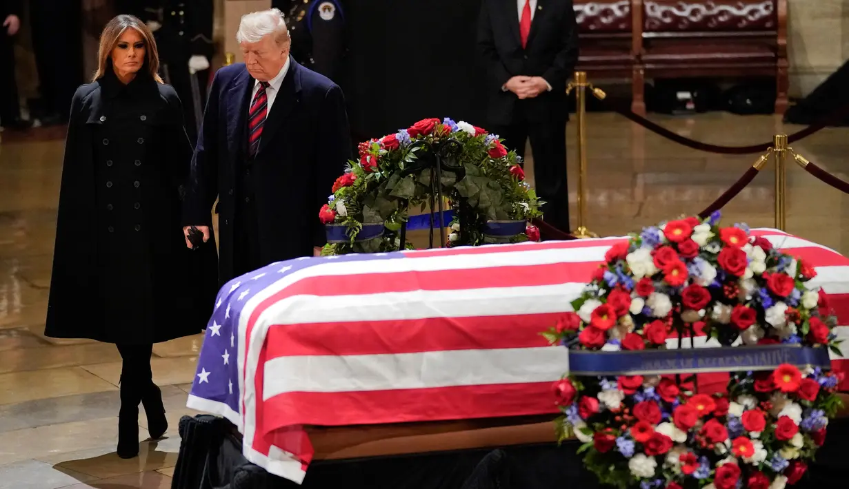 Presiden AS, Donald Trump dan Melania Trump saat akan memberikan penghormatan terakhir kepada George HW Bush di Gedung Capitol, Washington, Senin (3/12). Bush senior meninggal pada Jumat, 30 November 2018, di usia 94. (Pablo MARTINEZ MONSIVAIS/POOL/AFP)