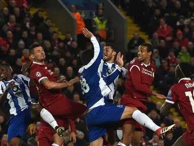 Bek Liverpool, Virgil van Dijk (kedua kanan) menyundul ke arah gawang FC Porto pada leg kedua babak 16 besar Liga Champions di Stadion Anfield, Selasa (6/3). Liverpool sukses melaju ke perempat final dengan bermain imbang tanpa gol. (PAUL ELLIS/AFP)