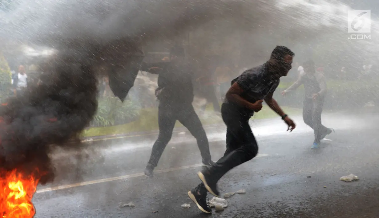 Massa membakar ban pada simulasi pengamanan Pemilu 2019 di depan Kantor KPU, Jakarta, Sabtu (16/3). Simulasi dalam rangka persiapan mengamankan Pilpres serta pemilihan legislatif pada 17 April mendatang. (merdeka.com/Imam Buhori)