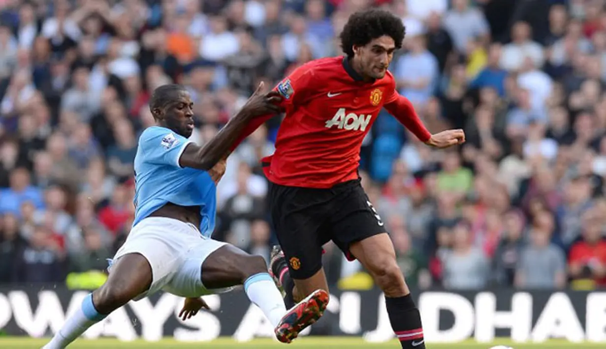 Gelandang Manchester United Marouane Fellaini (kanan) duel dengan bek Manchester City Yaya Toure pada pertandingan sepak bola Liga Inggris antara Manchester City vs Manchester United di Stadion Etihad, Manchester,  (22/09/13) (AFP/Andrew Yates)
