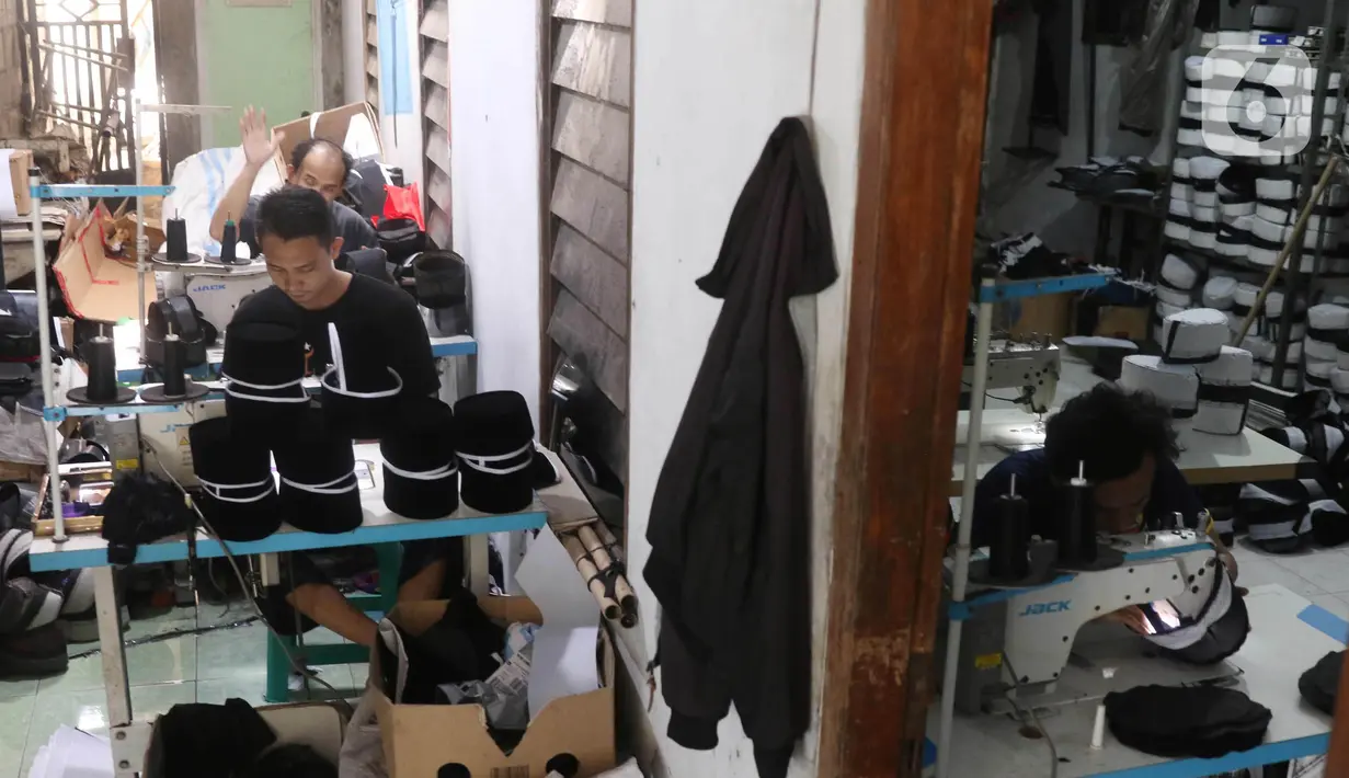 Pengrajin songkok (peci) sedang mengerjakan pesanan berbagai jenis peci di  Pasar Kemis, Kabupaten Tangerang, Banten, Minggu (18/4/2021). Bulan Bintang Mas Haji Sanusi sudah berproduksi sejak tahun 1964.  (Liputan6.com/Angga Yuniar)