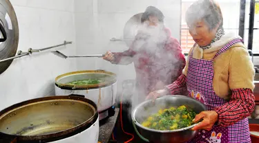 Sukarelawan memasak di sebuah kantin untuk warga lanjut usia (lansia) di Desa Yingshan, Kota Quanzhou, Provinsi Fujian, China pada 17 Desember 2020. Banyak desa dan komunitas di Quanzhou mendirikan kantin makanan gratis untuk warga berusia 60 tahun ke atas yang tinggal sendiri. (Xinhua/Wei Peiquan)