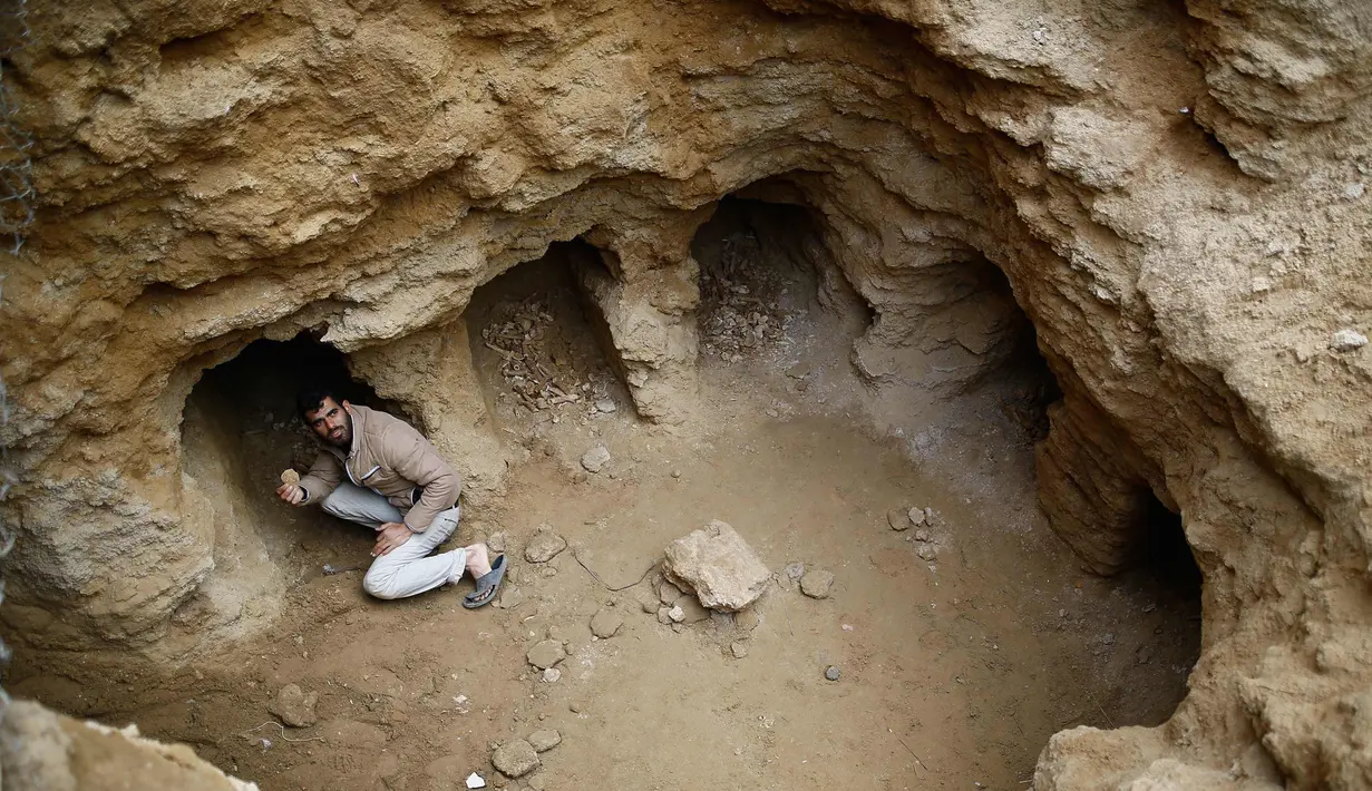 Abdel-Karim Cafran, warga Palestina Beit Hanun mengumpulkan pecahan tembikar di sebuah pemakaman yang baru ditemukan di kebun rumahnya di kota di Jalur Gaza utara, (26/1). (AFP Photo/Mohammed Abed)