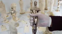Seorang spesialis pembuat Piala Oscar, Paul Pisoni menunjukan Piala Oscar yang sedang dibuatnya di tempat produksi Polich Tallix Fine Art Foundry, New York, AS (13/1). Piala Oscar tersebut terbuat dari perunggu dan disepuh emas 24 karat. (AFP/Don Emmert)